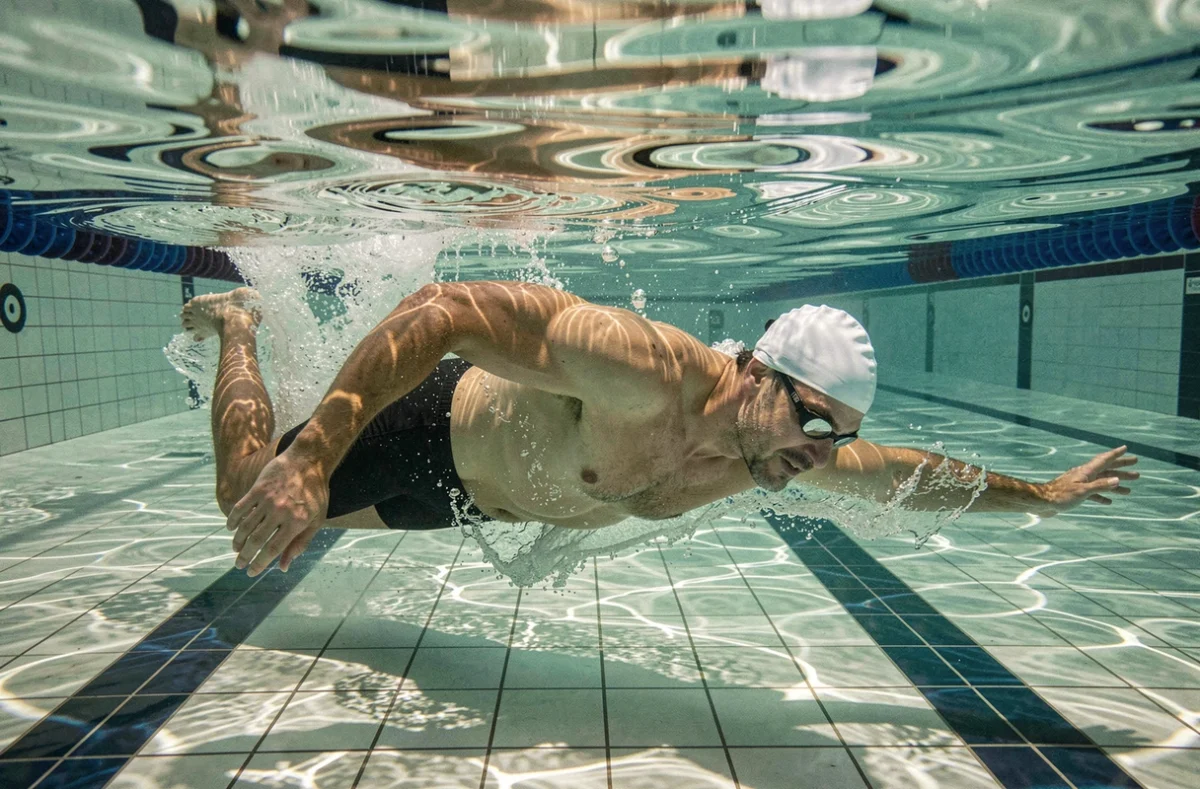 Nageur en plein crawl sous l'eau dans un bassin de piscine municipale à Nantes